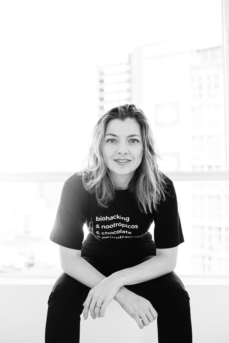 Camila Ferraz, fundadora do Ahnima Group, em estúdio com camiseta biohacking e nootrópicos